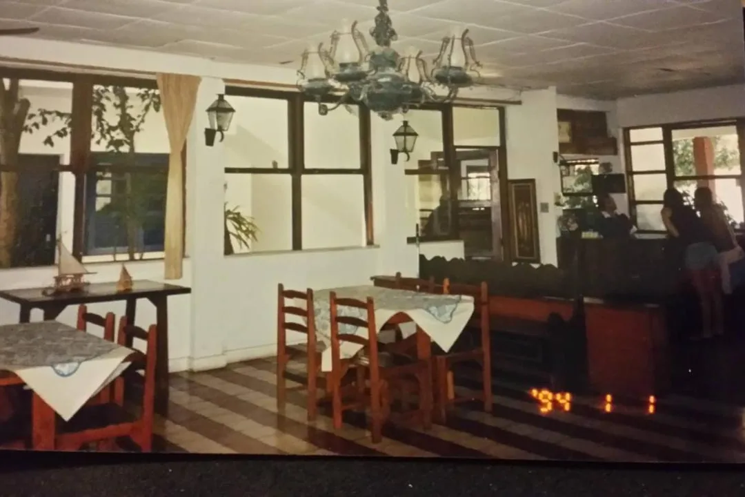 Salão em 1994 com lustre e mesas de toalha