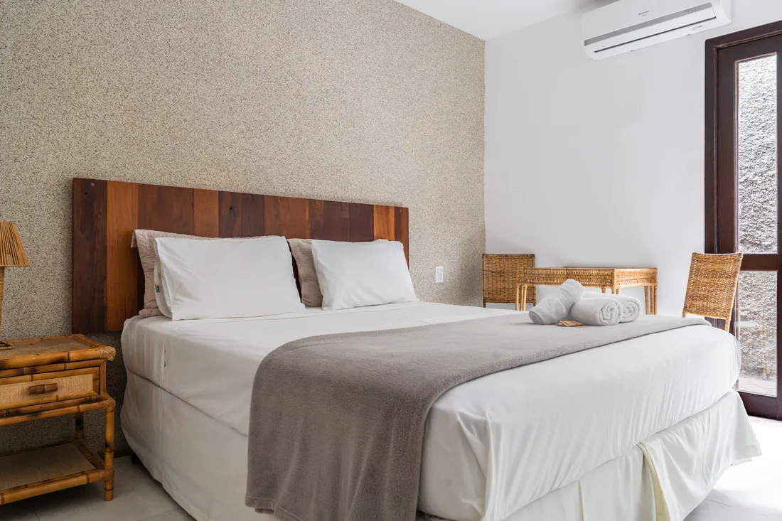 Quarto renovado com cabeceira de madeira