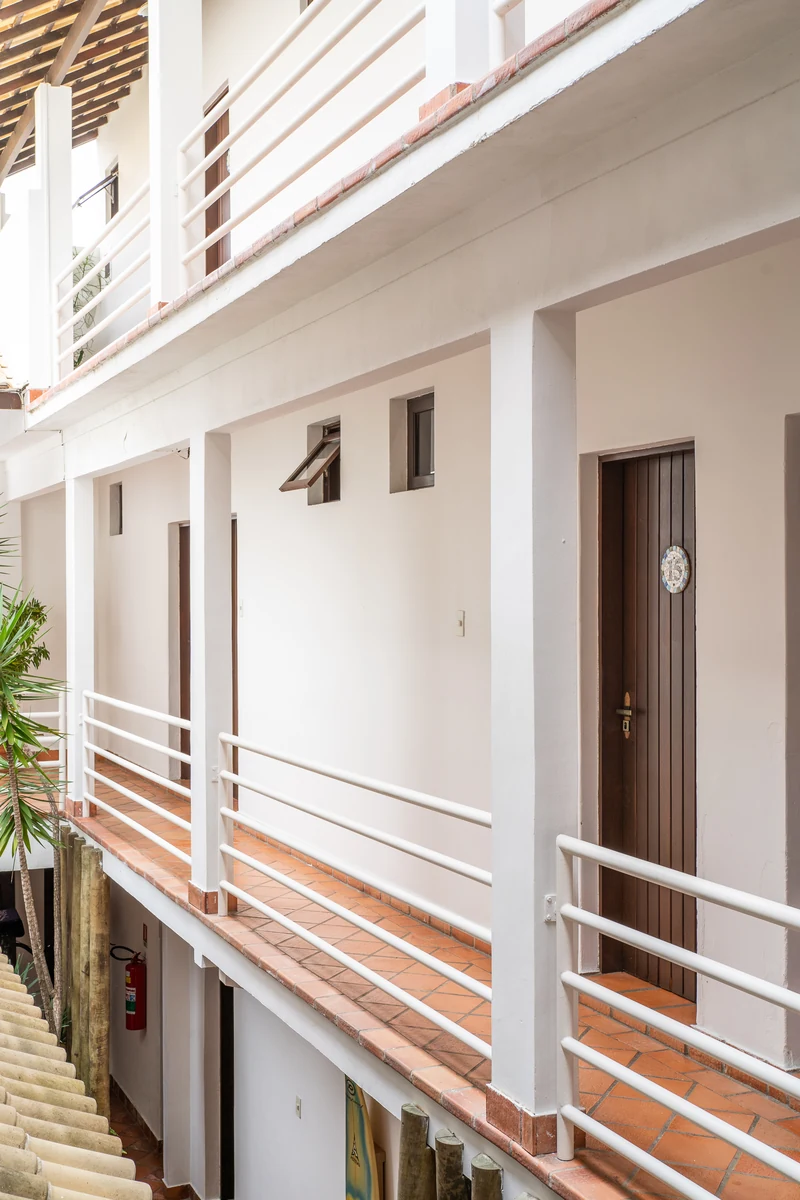 Corredores dos quartos em dois andares, com guarda-corpo branco