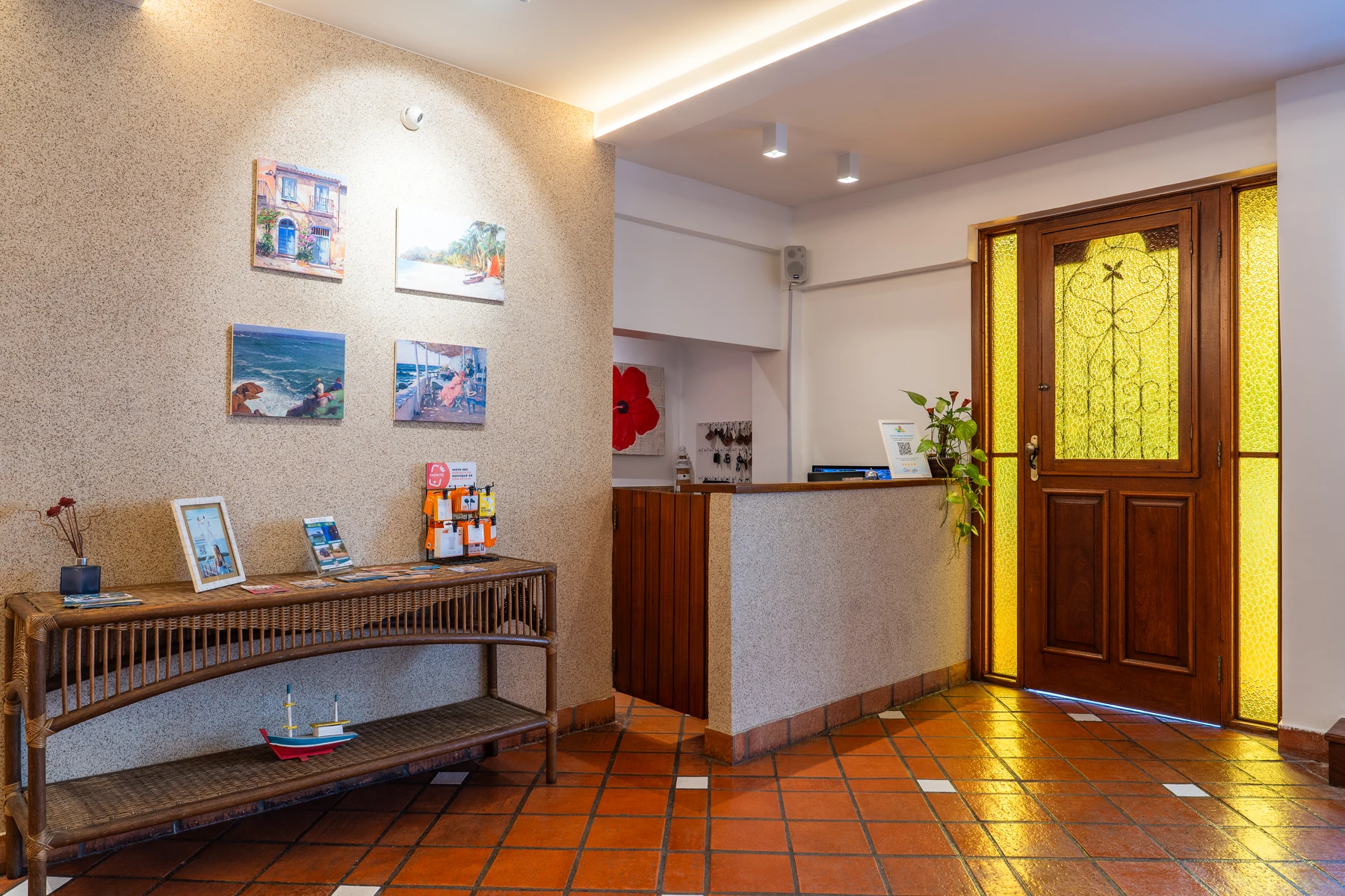 Recepção com quadros, porta de madeira e vitral