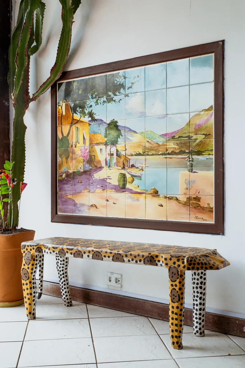 Painel de azulejo pintado e banco de onça de madeira