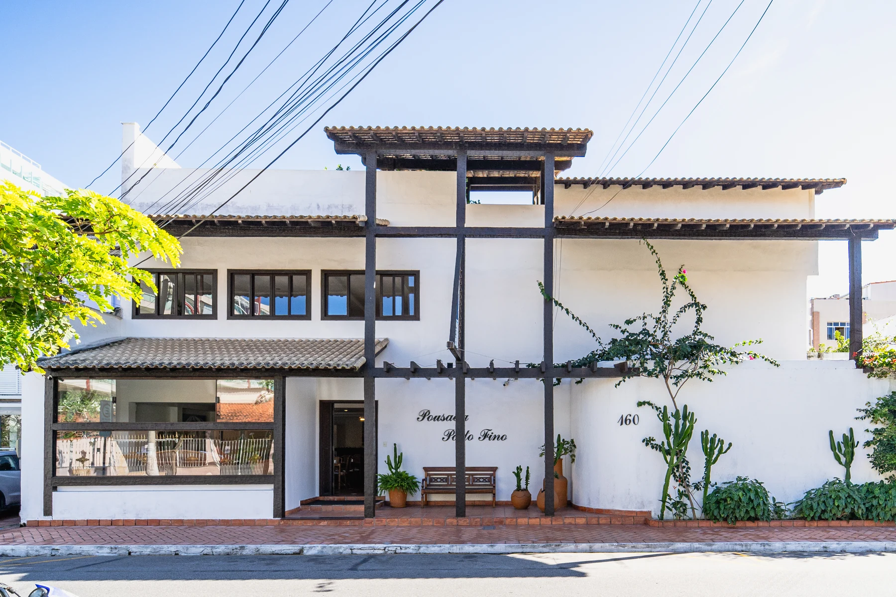 Salão com mesas de bambu, quadros e iluminação indireta