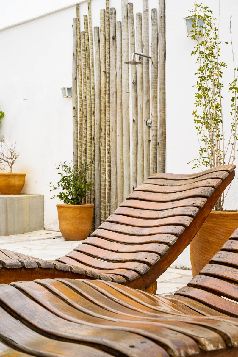 Espreguiçadeiras de madeira e ducha no solarium