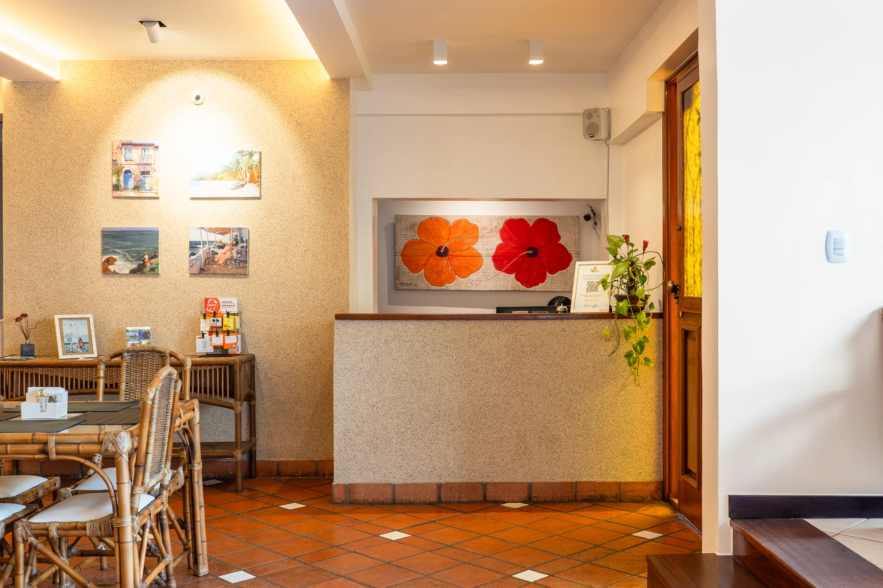 Balcão da recepção com quadro de hibiscos