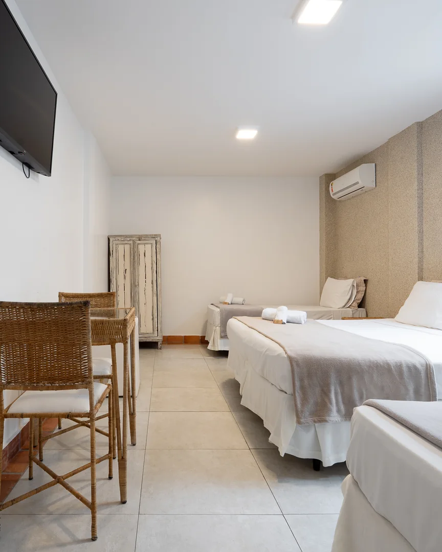Quarto quádruplo com TV, mesa e camas