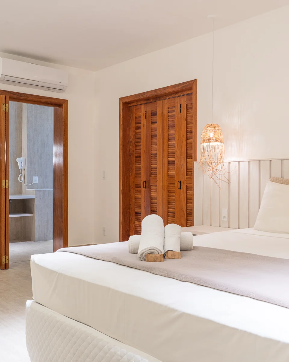 Suíte Master com cama king, armário de madeira e porta para o banheiro