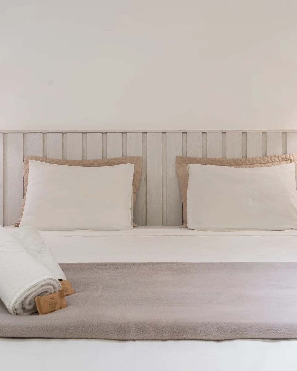 Cama da Suíte Master com toalhas e luminárias de palha