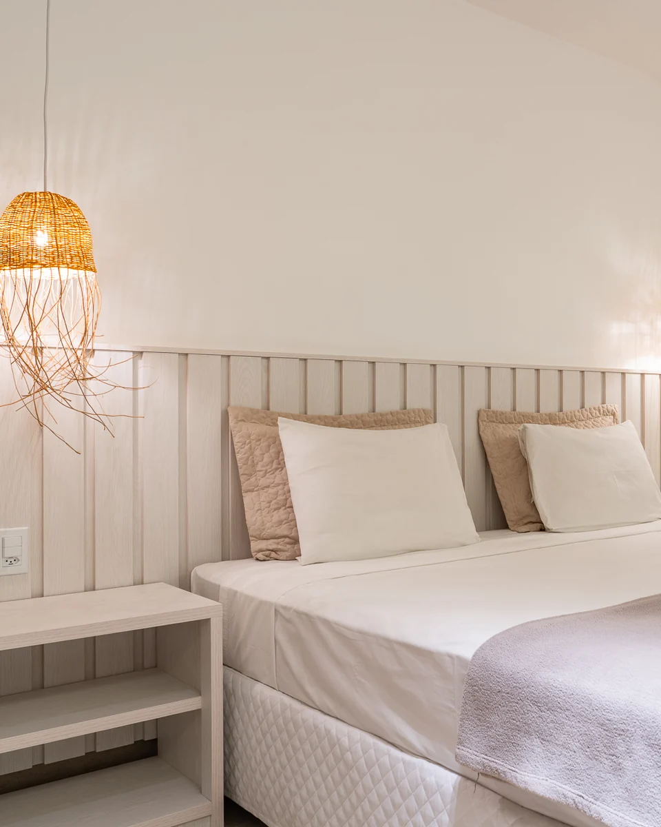 Cama da Suíte Master com luminária de palha e espelho
