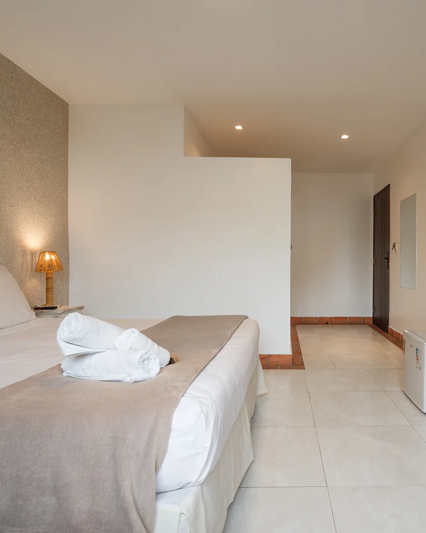 Cama de casal, frigobar e TV no quarto triplo